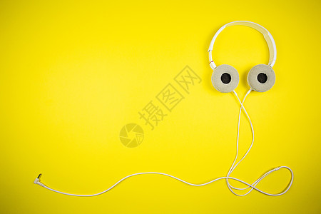 黄色背景上带 3 5 毫米线的白色音频耳机电脑技术立体声绳索耳朵插图麦克风配饰音乐播放器娱乐图片