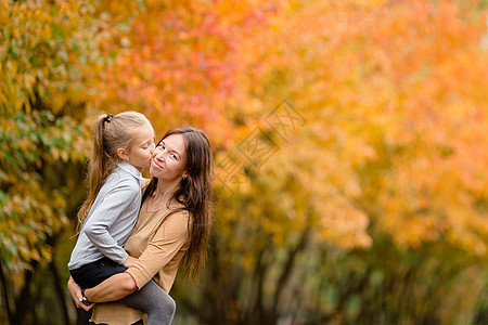 秋天在公园户外露宿的妈妈和小孩家庭季节树木情绪母亲女儿跑步树叶成人童年父亲图片