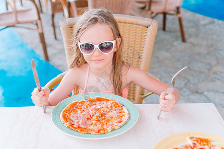 坐在晚餐桌边吃披萨的可爱小女孩的肖像早餐快乐童年盘子面团小吃桌子青年女孩女儿图片