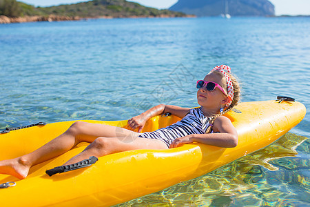 美丽的可爱小姑娘喜欢在清蓝的海面上划皮艇图片