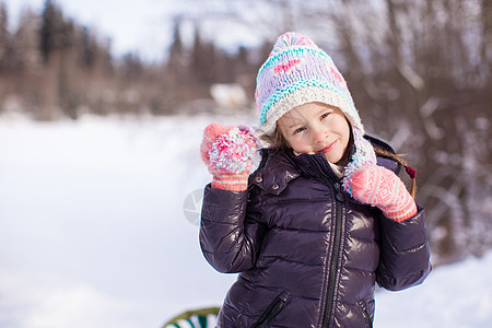 在阳光明媚的冬天天雪中 可爱小女孩的肖像图片