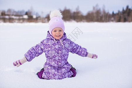 快乐的小女孩 在寒冬阳光明日雪雪上玩得开心薄片森林活动童年紫色雪花假期幸福乐趣围巾图片