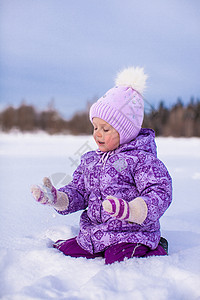 快乐的小女孩 在寒冬阳光明日雪雪上玩得开心孩子围巾假期草地衣服女儿薄片森林闲暇紫色图片