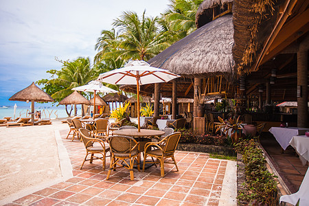 热带海滩的户外咖啡馆扶手椅餐厅桌子露台瓶子家具旅行午餐海洋咖啡店图片