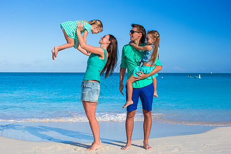 年轻快乐的家庭和两个孩子在暑假女士阳光海滩母亲孩子们女性女儿情调父母幸福图片