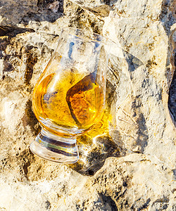 在石头上的玻璃杯里 一杯纯麦威士忌 在自然的圣杯上喝酒环境蓝色玻璃悬崖岩石砂岩烈酒闲暇侵蚀活力图片