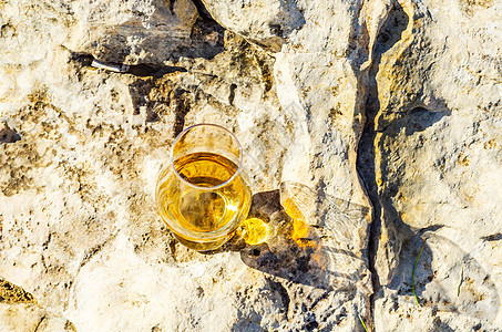 在石头上的玻璃杯里 一杯纯麦威士忌 在自然的圣杯上喝酒编队蓝色岩石玻璃闲暇环境砂岩烈酒侵蚀矿物图片