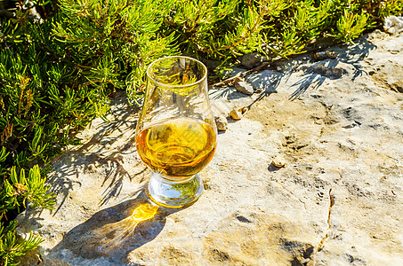 在石头上的玻璃杯里 一杯纯麦威士忌 在自然的圣杯上喝酒麦芽烈酒砂岩玻璃活力饮料闲暇编队蓝色悬崖图片