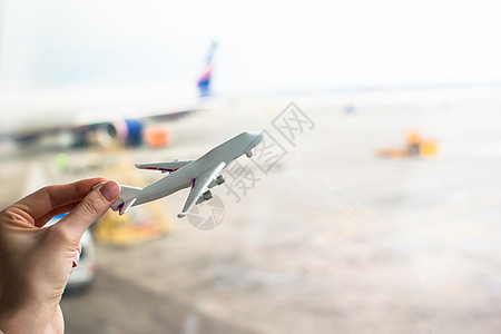 近手握着机场的飞机型号空气航班广告喷射航空玩具假期旅游运输货物图片