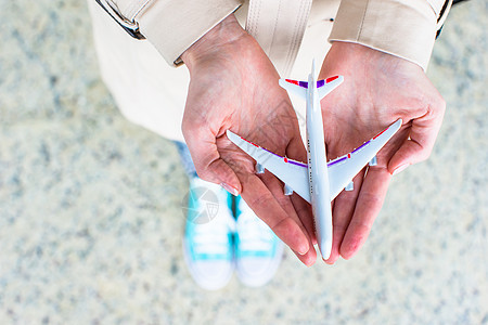在机场拿着飞机型号的紧贴手空气客机人士商业公司货物旅行天空玩具喷射图片