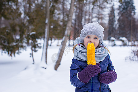 冬天天在户外吃玉米的小女孩公园金子童年植物午餐蔬菜野餐粮食食物种子图片