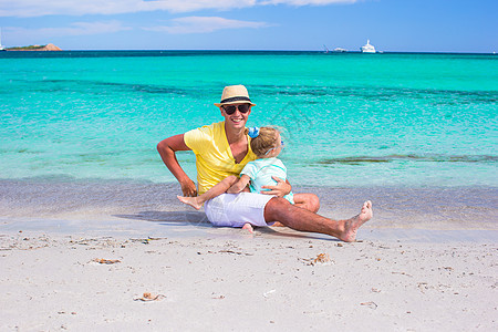 年轻父亲和小女儿在沙滩上玩得开心家庭海岸线父母快乐海滩女性假期热带成人婴儿图片