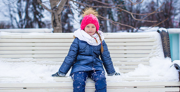 冬天在公园户外的可爱小女孩 在寒冬日女孩女性幸福童年毛皮微笑雪花孩子雪堆晴天图片