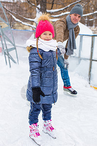 在户外滑冰溜冰场上快乐的一家人训练女孩爸爸数字男性父亲闲暇学习女儿孩子图片