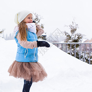 可爱的小女孩在冬冬户外玩雪球手套天气闲暇公园乐趣女儿季节外套童年晴天图片