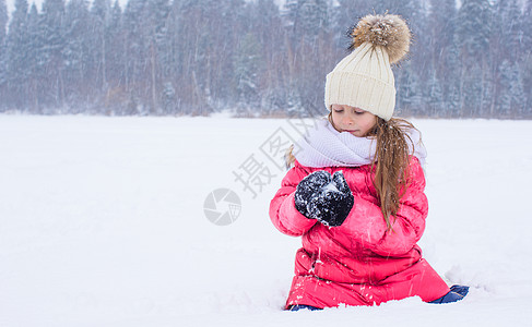 快乐可爱可爱的小女孩 在雪寒日玩雪球图片