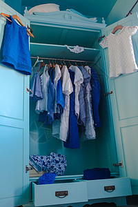 衣柜里装着蓝色衣服的衣橱女士橙子店铺围巾服装裙子音调衬衫精品架子图片