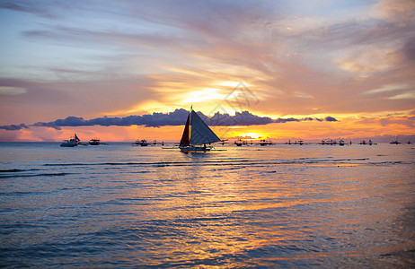 在美丽多彩的夕阳下航行血管日落游客活动橙子地平线游艇阳光海洋天空图片