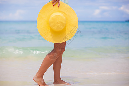 紧紧的黄色帽子 在海滩上的女性手天堂乐趣游客旅行娱乐热带成人头发女士女孩图片