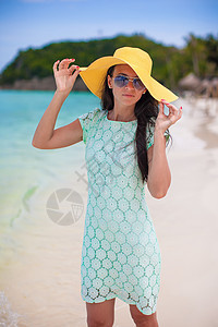 在沙滩上穿着帽子和服装的年轻时装女郎女性热带乐趣海滩女士旅行假期支撑地平线幸福图片