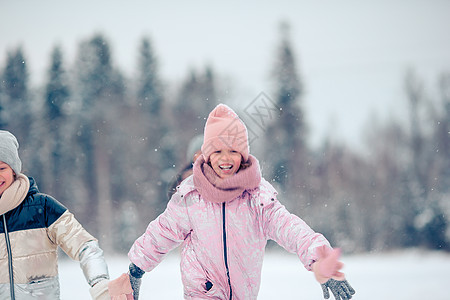 在阳光明媚的冬天天下雪时 可爱小女孩的肖像季节孩子外套幸福公园兜帽夹克围巾婴儿乐趣图片