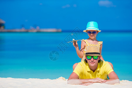 年轻男子和小女孩在海滩上拥有小飞机的小型飞机男性女儿航班工艺行动天空教育手工童年家庭图片