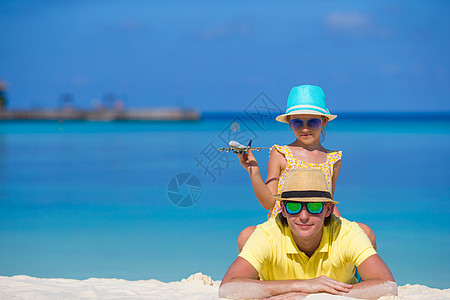 年轻男子和小女孩在海滩上拥有小飞机的小型飞机家庭假期空气旅行婴儿自由教育幸福手工喷射图片