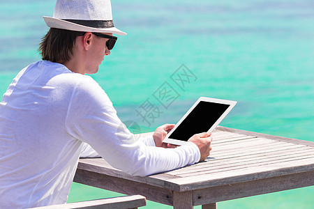 暑假时在户外咖啡馆带平板电脑的青年男子工人记事本男人上网展示男性商务假期旅行技术图片