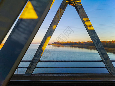 从火车桥看到海岸和Swinoujscie树上美丽的日出图片