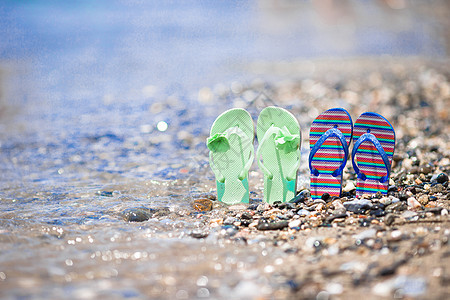 孩子们在海面海滩上翻滚海浪微风乐趣旅行支撑宏观蓝色拖鞋季节旅游图片