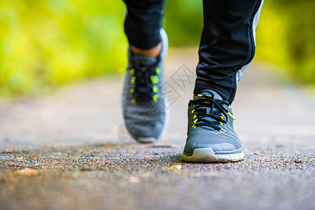 紧贴在路上行走的运动员跑步男子脚鞋鞋上运动娱乐男人训练踪迹赛跑者公园慢跑者速度慢跑背景图片