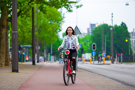 欧洲城市骑自行车的年轻快乐女人女性女士旅游太阳镜建筑学毛衣街道照片旅行蓝色图片