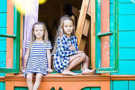 住在户外农村家庭窗户窗中的可爱的小女孩微笑喜悦幸福橙子房子农家天空乐趣细胞姐姐图片