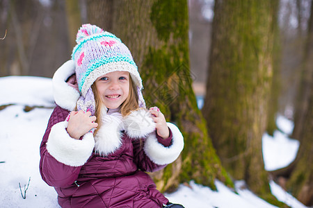 可爱的小女孩在冬假期间玩得开心公园闲暇季节帽子天气外套手套女性雪花森林图片