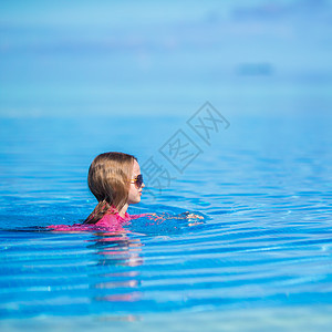 在户外游泳池里 快乐可爱的小女孩热带婴儿游泳镜童年幸福水池蓝色喜悦太阳镜闲暇图片