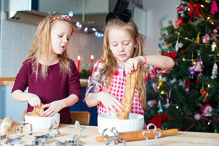 快乐的小姑娘们 在家厨房为圣诞节烤姜饼做圣诞饼干烹饪面包帮助滚动糕点面团蛋糕家庭食物女孩图片
