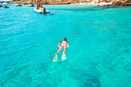 年青活跃女孩在度假时在热带水中潜水图片