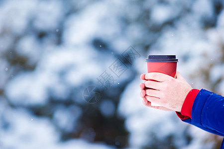 在寒冷的冬日户外 喝咖啡的密闭男子男人木头饮料降雪闲暇可可杯子叶子快乐手套图片