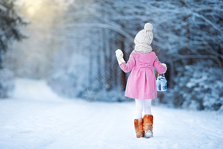 在冬季的Xma 晚夜露户外带灯和蜡烛的可爱女孩森林手电筒闲暇降雪魔法女性灯笼新年外套围巾图片