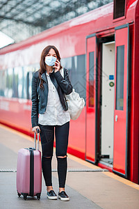 城市速度在平台上行李在等待火车的年轻旅游妇女 等候火车女士运输城市车站铁路旅行游客速度飞机女孩背景