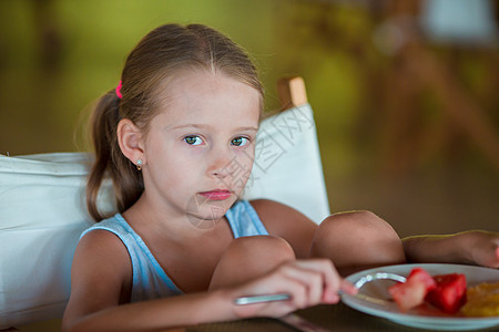 可爱的小女孩在户外咖啡厅吃早餐女儿水果食物餐巾假期午餐杯子稀饭喜悦西瓜图片