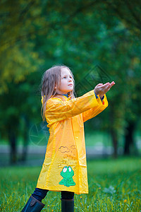 穿着防水外套的可爱幼儿女孩在雨天和阳光下户外玩耍微笑天气飞溅童年水坑夹克雨衣预报风暴橡皮图片