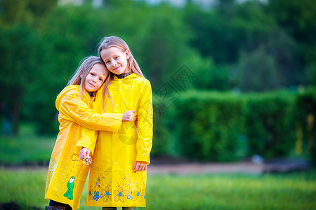 穿着防水大衣的可爱可爱小可爱女孩在雨天和阳光下户外玩耍下雨童年夹克孩子微笑雨衣飞溅预报天气季节图片