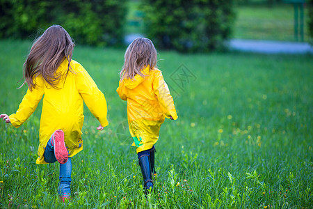 穿着防水大衣的可爱可爱小可爱女孩在雨天和阳光下户外玩耍外套预报橡皮童年季节水坑微笑飞溅雨衣孩子图片