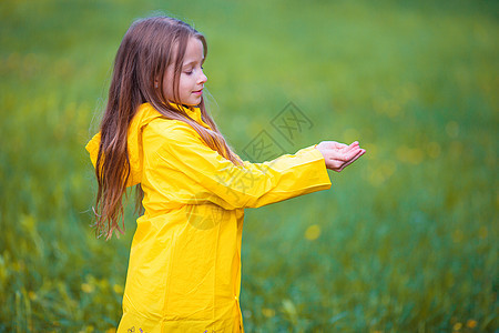 穿着防水外套的可爱幼儿女孩在雨天和阳光下户外玩耍雨衣女孩天气夹克风暴童年下雨孩子橡皮微笑图片