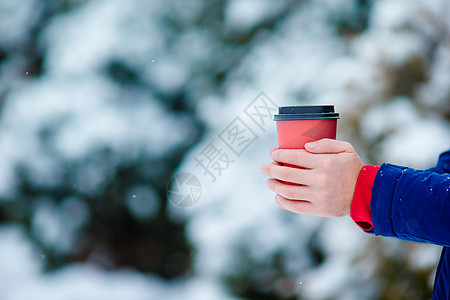 在寒冷的冬日户外 将咖啡放在男性手中降雪天气帽子快乐闲暇成人手套冷冻饮料男人图片