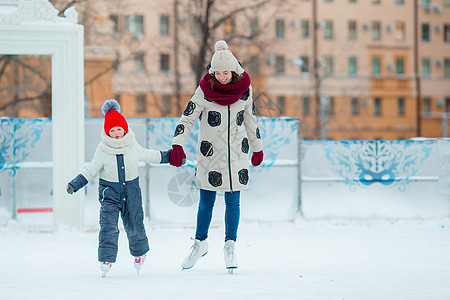 可爱的小女孩 她妈妈在冰加冰上溜冰童年滑冰女孩女儿手套喜悦娱乐闲暇爱好幸福图片
