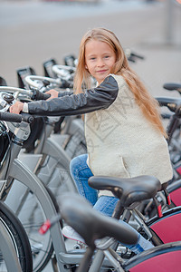 在美丽的夏日露天户外 骑自行车的可爱女孩快乐幸福森林微笑童年幼儿园季节人行道运输踏板图片