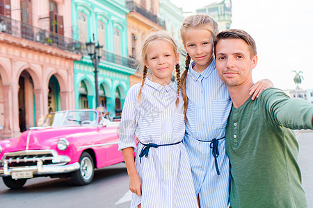 古巴旧哈瓦那流行地区的家庭 两个孩子和年轻父亲的肖像在哈瓦那大街上露天出现图片