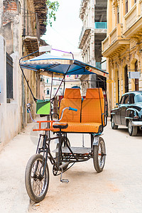 古巴出租车自行车停在多彩殖民房屋前的古巴计程车高清图片